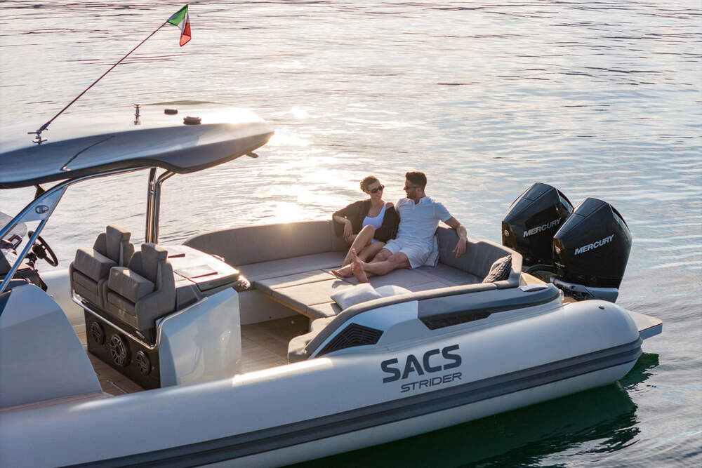 A couple lounging on the Sacs Strider 11, enjoying the sunset