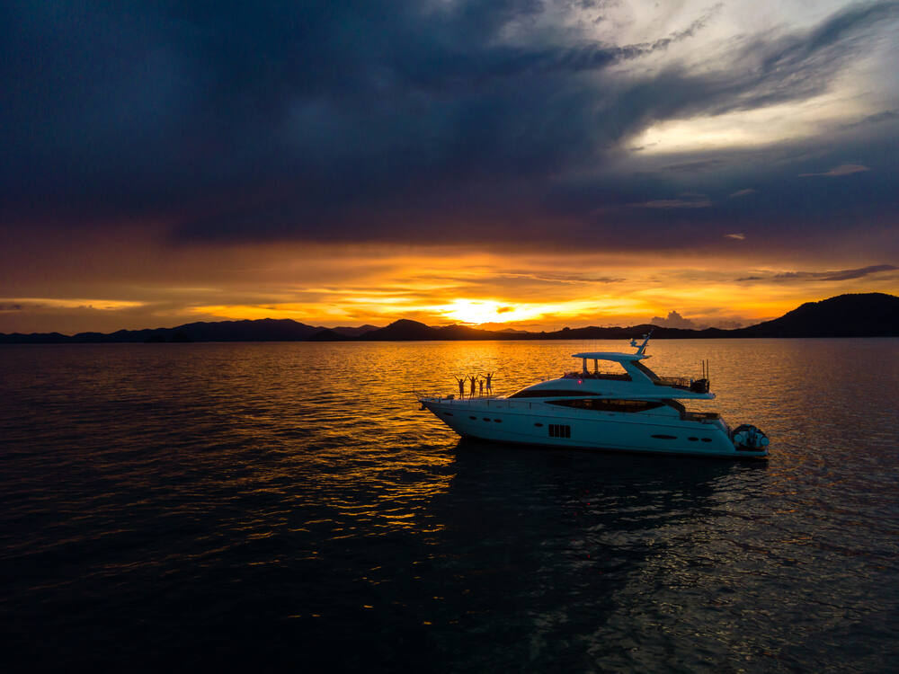 A Princess Yacht cruising through the water during sunset 